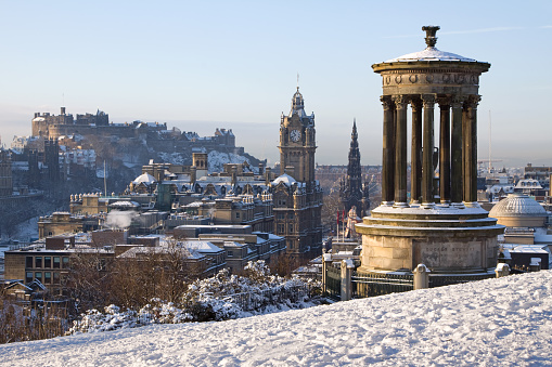 Edinburgh City and Castle viewed from Calton Hill on a beautiful winter morning with the Dugald Stewart monument in the foreground and the castle, Scott monument and Balmoral clock tower in the background.