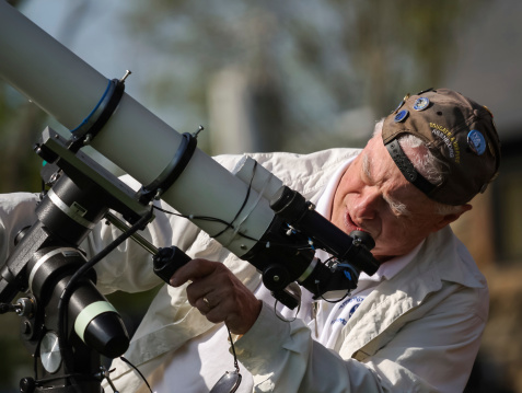 Barrington, Rhode Island, USA - April 21, 2012: An amateur astronomer and member of the Astronomical Society of Southern New England sets up a telescope on International Astromy Day for a volunteer public outreach event