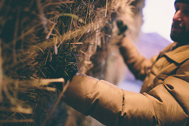 Hard working man grabs hay bale stacked in barn
