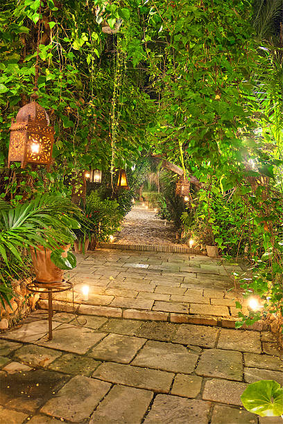 istock Wonderful garden path at night, illuminated by candles, and lanterns. 506398513