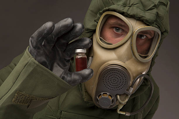 istock Man in a hazmat Suit holding vial 506398523