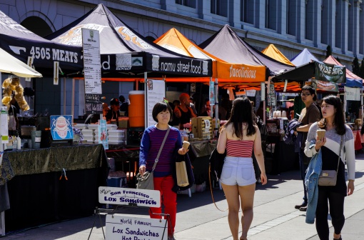 San Francisco, USA - May 29, 2014: People enjoying a sunny day at the Embarcadero, an open air market with stands and restaurants in downtown San Francisco, California.