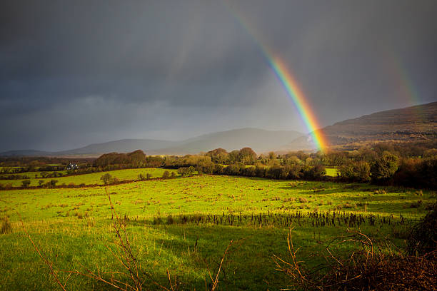 Beautiful Colours Of A Rainbow In The Irish Countryside Sunshine and rainbows competing against the rain. All four seasons at once. northern ireland photos stock pictures, royalty-free photos & images