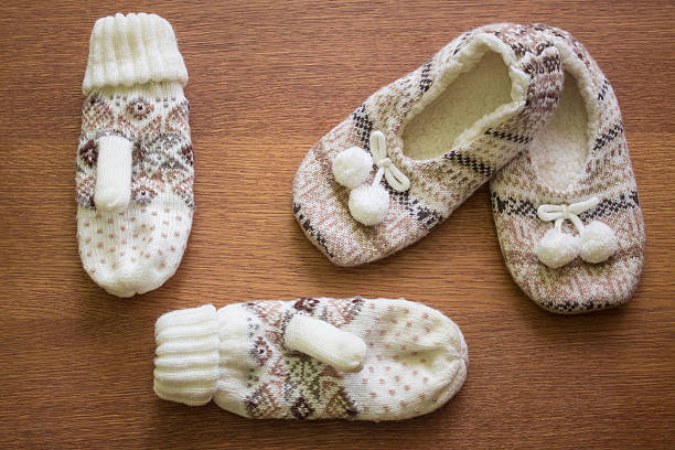 istock Knitted slippers with pompoms and mittens 506399660