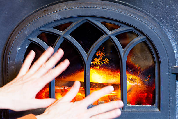 istock Woman warming her hands at fire fireplace interior. Heating. 506400471