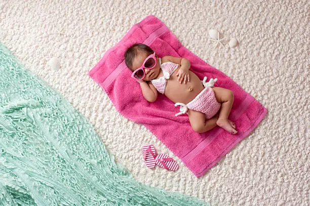 Photo of Newborn Baby Girl Wearing a Bikini and Sunglasses