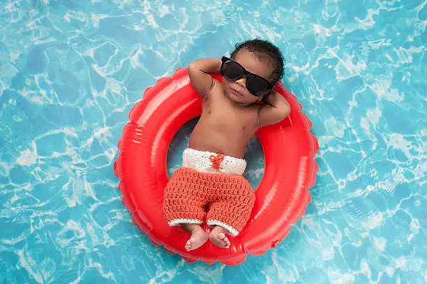 Photo of Newborn Baby Boy Floating on a Swim Ring