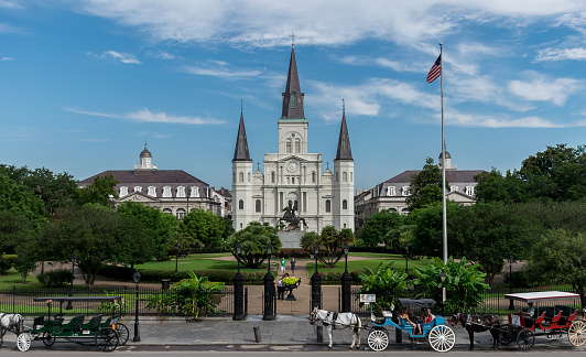 New Orleans, LA USA - June 10, 2015: Horse carriages await tourists in front of the Saint Louis Cathedral in New Orleans' French Quarter. 