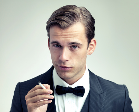 A cropped portrait of a confident young gentleman smoking a cigarettehttp://195.154.178.81/DATA/shoots/ic_784009.jpg