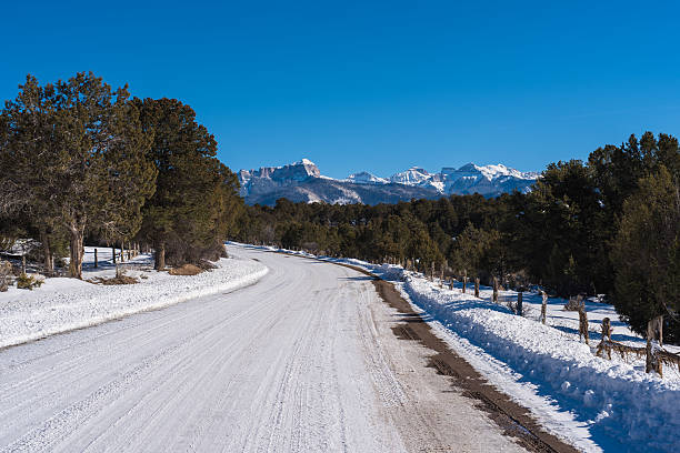 camino cubierto nieve país cimarron dirigiendo a las montañas. - uncompahgre national forest fotografías e imágenes de stock