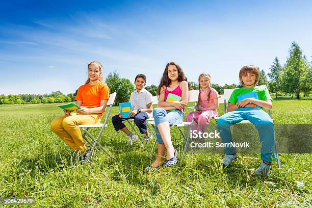 School Children Hold Notebooks And Sit On Chairs Stock Photo - Download Image Now - African Ethnicity, Arabia, Beautiful People