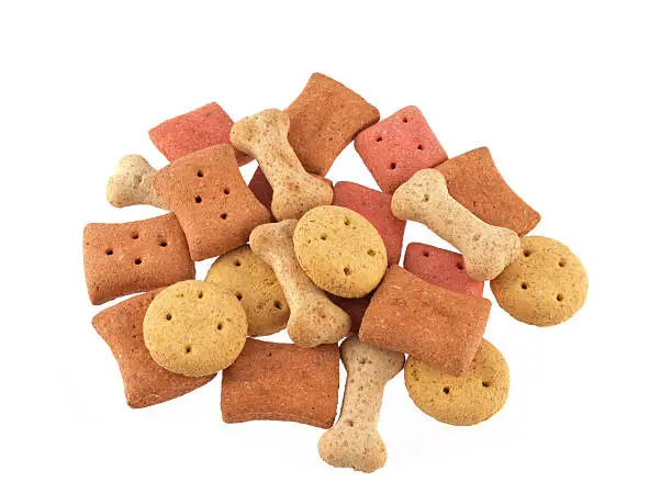 Close up of assorted shaped dog biscuits on a white background.