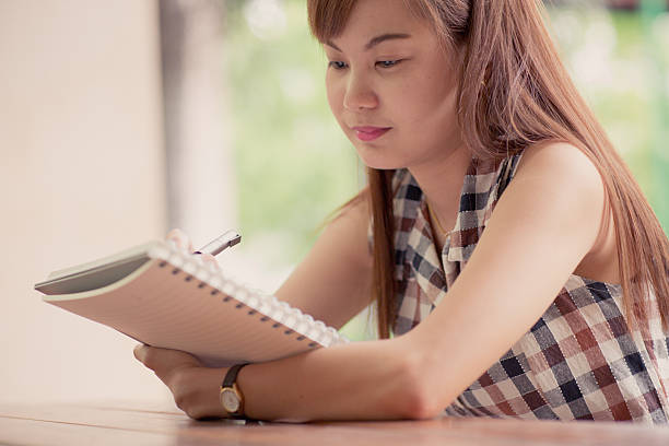 istock Close-up of a young girl writing into her diary, 506431609