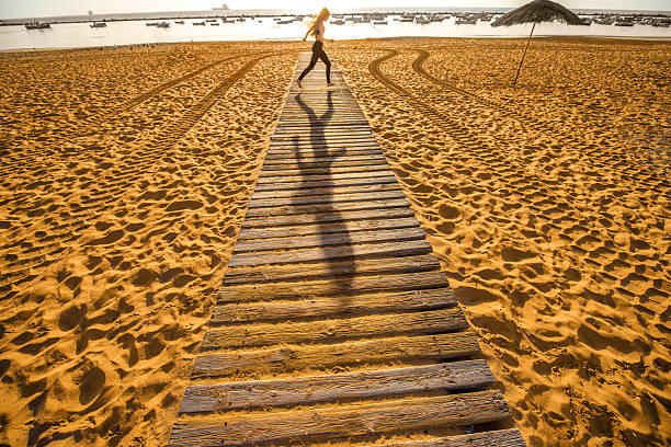 istock Sandy beach with shadow of running woman 506432472