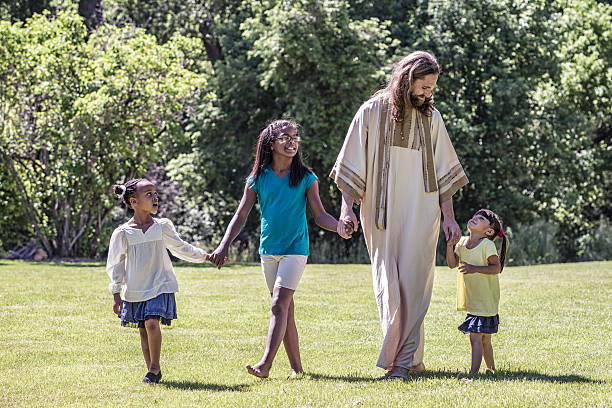 Jesus Christ Walking With Children - Three Young Girls Jesus Christ is walking in an open grass meadow holding hands with a teenager and her two younger sisters. All three ethnically diverse girls are listening and looking up at Jesus as he talks and teaches and leads them forward. apostle worshipper stock pictures, royalty-free photos & images