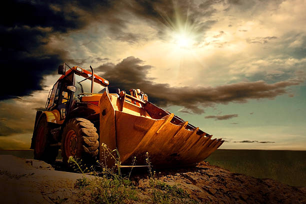 желтый трактор на небесный фон - earth mover working field dirt стоковые фото и изображения