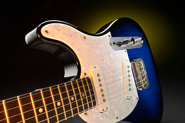 Close-up of Two Guitar Headstocks Against White Background
