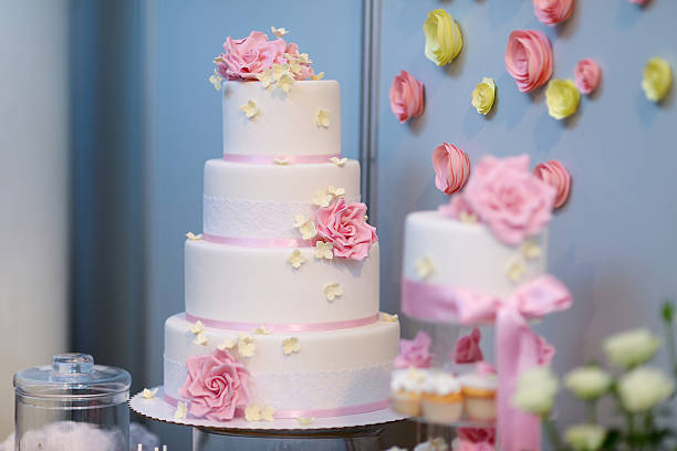istock White wedding cake decorated with pink flowers 506438412