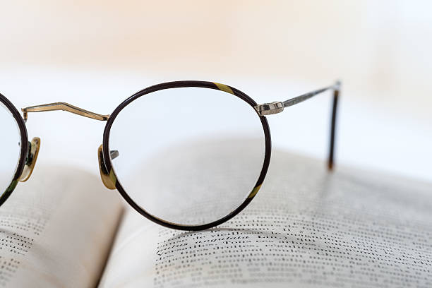 istock Old books with eye glasses isolated on white background 506440186