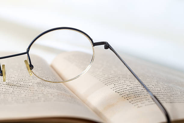 istock Old books with eye glasses isolated on white background 506440254