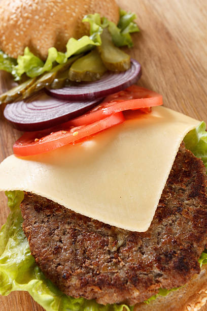 istock Traditional American cheeseburger. Meat, bun and vegetables close up 506440844