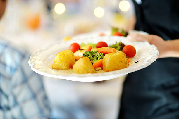 Waitress carrying a plate with vegetable dish