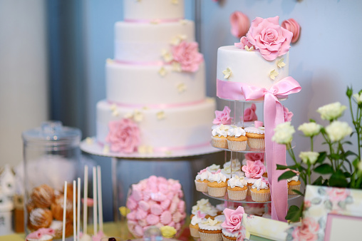 White wedding cupcake cake decorated with pink flowers