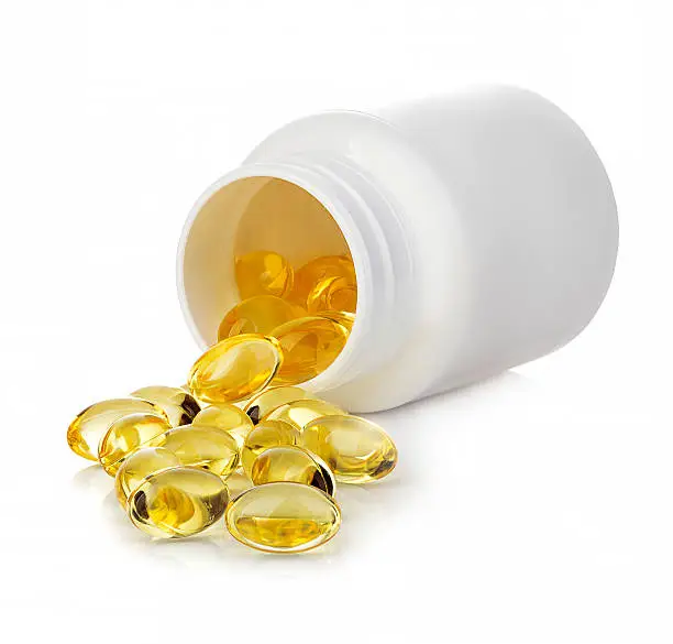 Photo of Soft gels pills with Omega-3 spilling out of pill bottle.