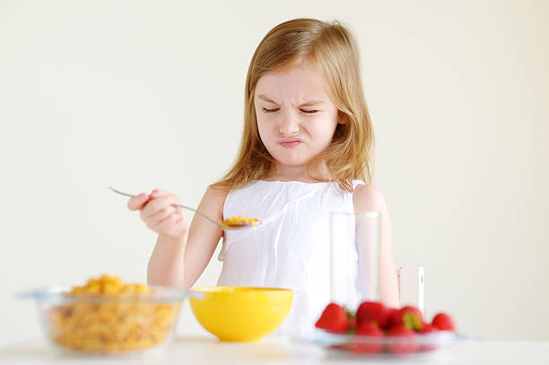 istock Adorable little girl eating cereal in a kitchen 506442256