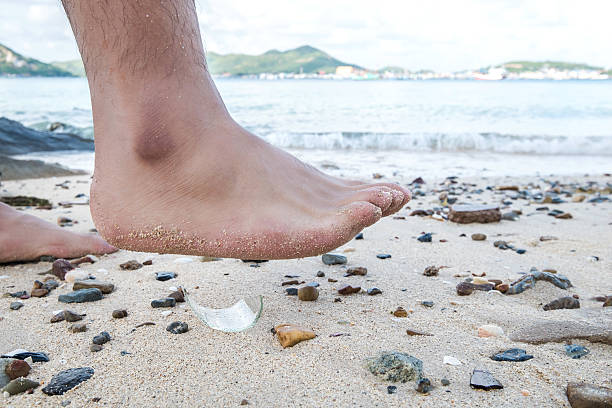 istock Barefoot walking on the beach,with risk step on glass 506446350