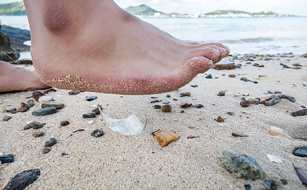 istock Barefoot walking on beach,with risk to step on glass 506446428