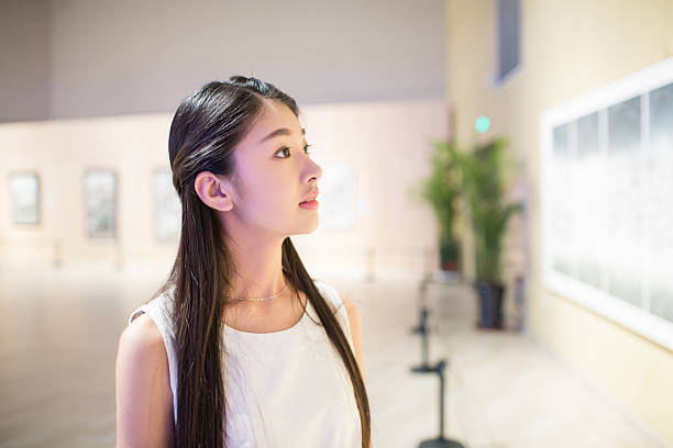 pretty young chinese girl, alone in the museum visit china painting exhibition.