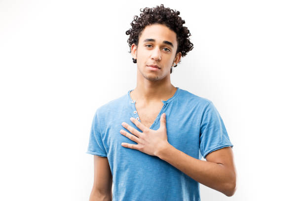 istock hand on the heart by this young man 506446748