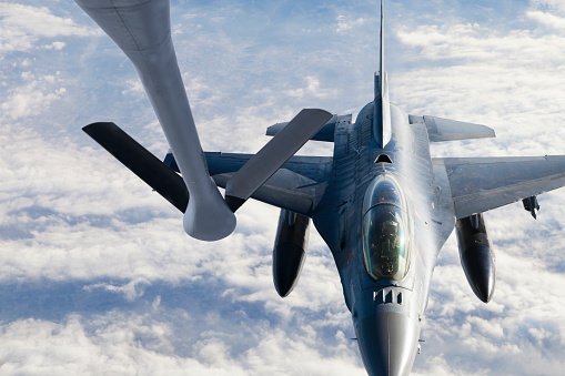 Mid-air refueling of an F-16 from the boom pod of a KC-135 Stratotanker.