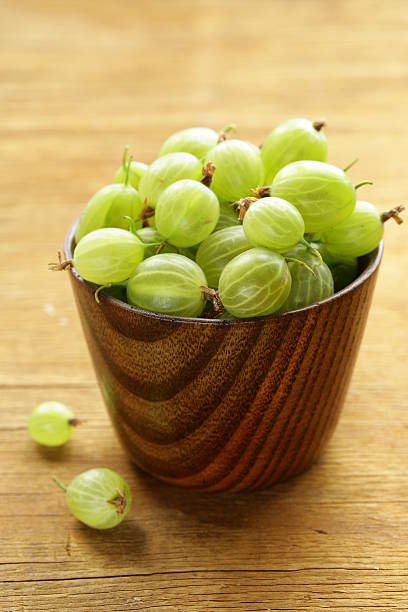 istock fresh ripe green gooseberries on wooden table 506465501