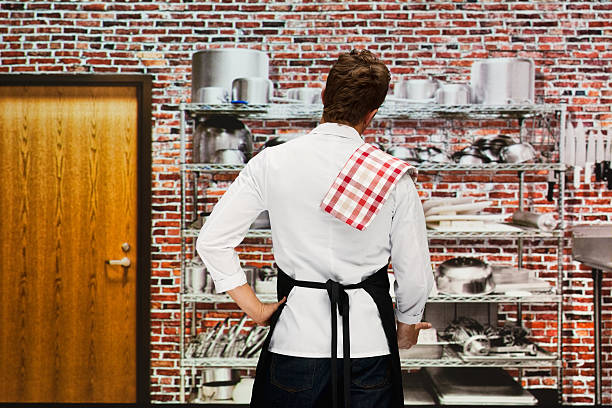 istock Rear view of chef standing in kitchen 506468292