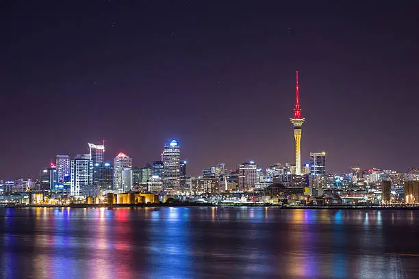 New Zealand's biggest city at night time with beautiful still water of the Waitemata Harbour reflecting the city lights