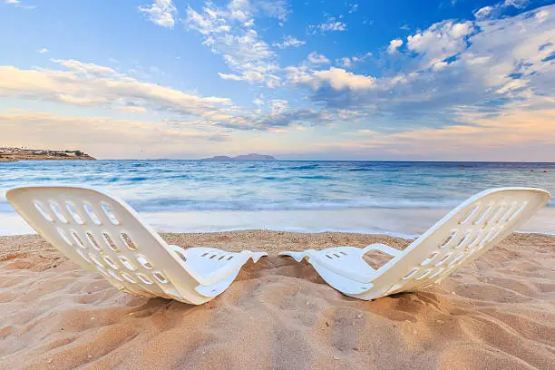 Landscape of Two Lonely beachchairs on the sand near sea in the morning at a perfect beach in Egypt