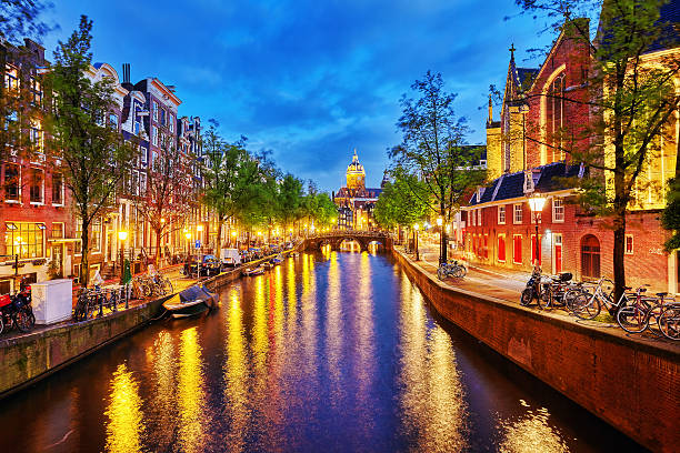 igreja ocidental westerkerk (), com água, vista de canal em amsterdão. - amsterdam holland city night imagens e fotografias de stock