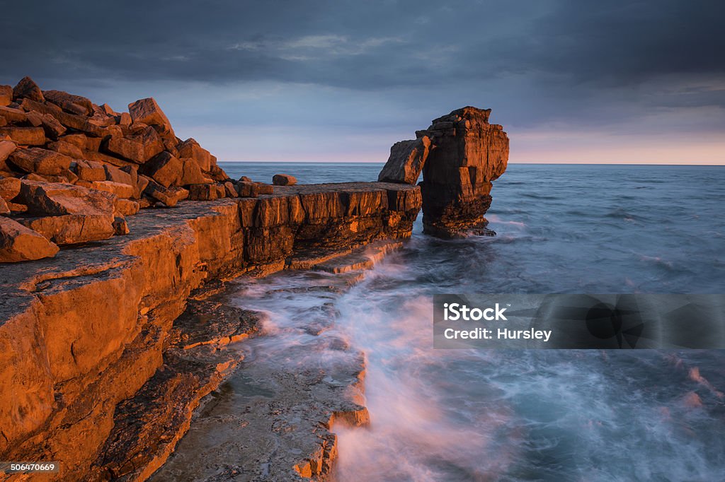 Golden light on Pulpit Rock The last rays of a golden sun illuminate Pulpit Rock on the Dorset Coast, UK Dorset - England Stock Photo