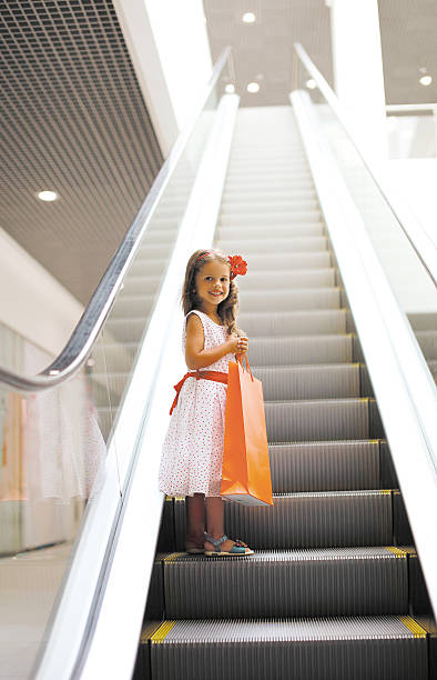 少女のモールでショッピングバッグ - escalator child shopping mall little girls ストックフォトと画像