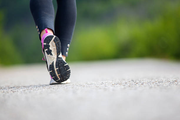 istock Runner feet running on road closeup on shoe 506472401