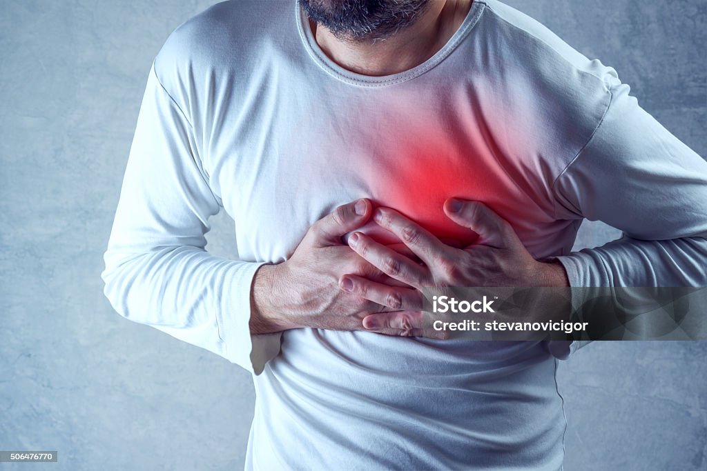 Severe heartache, man suffering from chest pain, having painful Severe heartache, man suffering from chest pain, having heart attack or painful cramps, pressing on chest with painful expression. Heart Attack Stock Photo