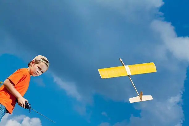 Photo of Little boy playing with handmade RC airplane toy