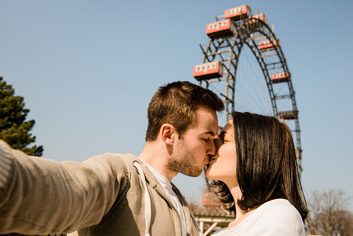 Vienna, Prater - couple kissing and hugging in front of ferris wheel