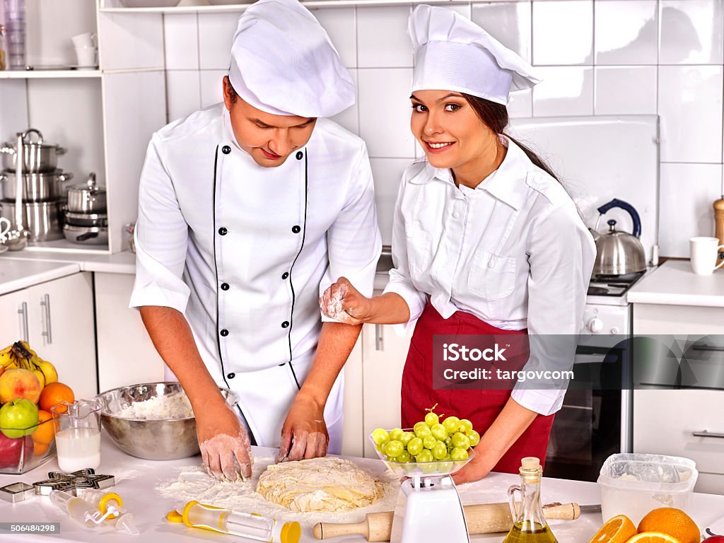Donna Uomo In Cappello Chef Cucinare Il Pollo - Fotografie stock e