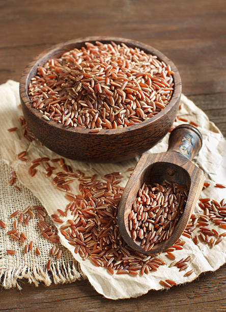istock Uncooked Red rice in a bowl with a wooden spoon 506484908