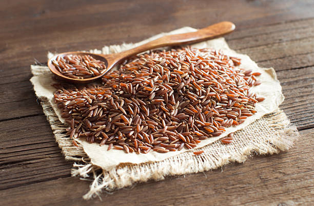 istock Uncooked Red rice with a wooden spoon 506485314