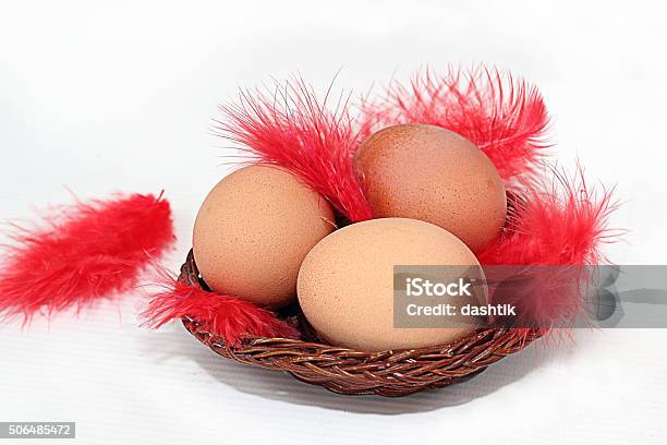 Eggs In A Basket And Feather Stock Photo - Download Image Now - Animal, Basket, Bird