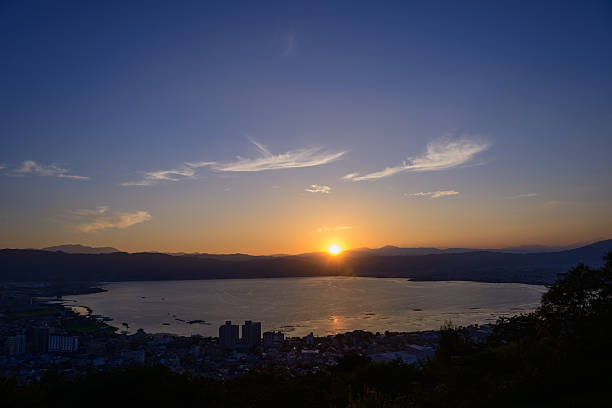The city of Suwa at the moment of sunset The city of Suwa at dusk. The Suwa region is the leading industrial area of Nagano and was once known as "The Oriental Switzerland" for its highly developed precision machinery industry. suwa lake photos stock pictures, royalty-free photos & images